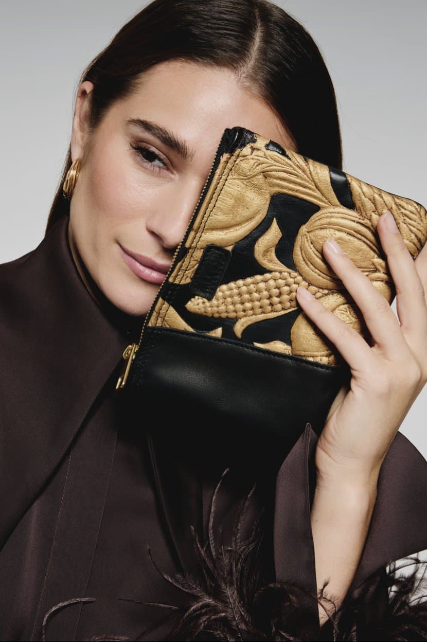 Campaign shot: gilded leather clutch held to the face